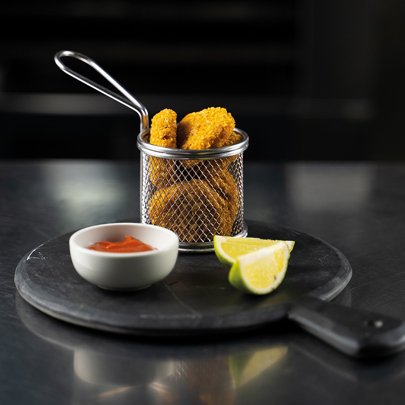 Immagine di nuggets vegani croccanti con salsa al tabasco e fettine di lime, serviti su un piatto rustico.
